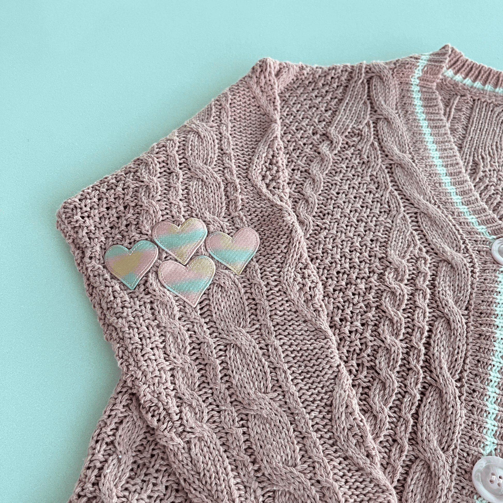 Knitted fabric with heart-shaped pins on a light blue background