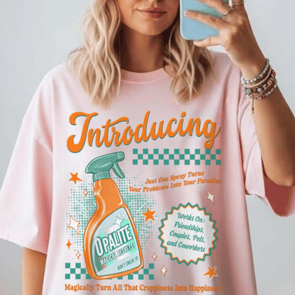 Person wearing a pink t-shirt with a graphic design of a cleaning product bottle and text.