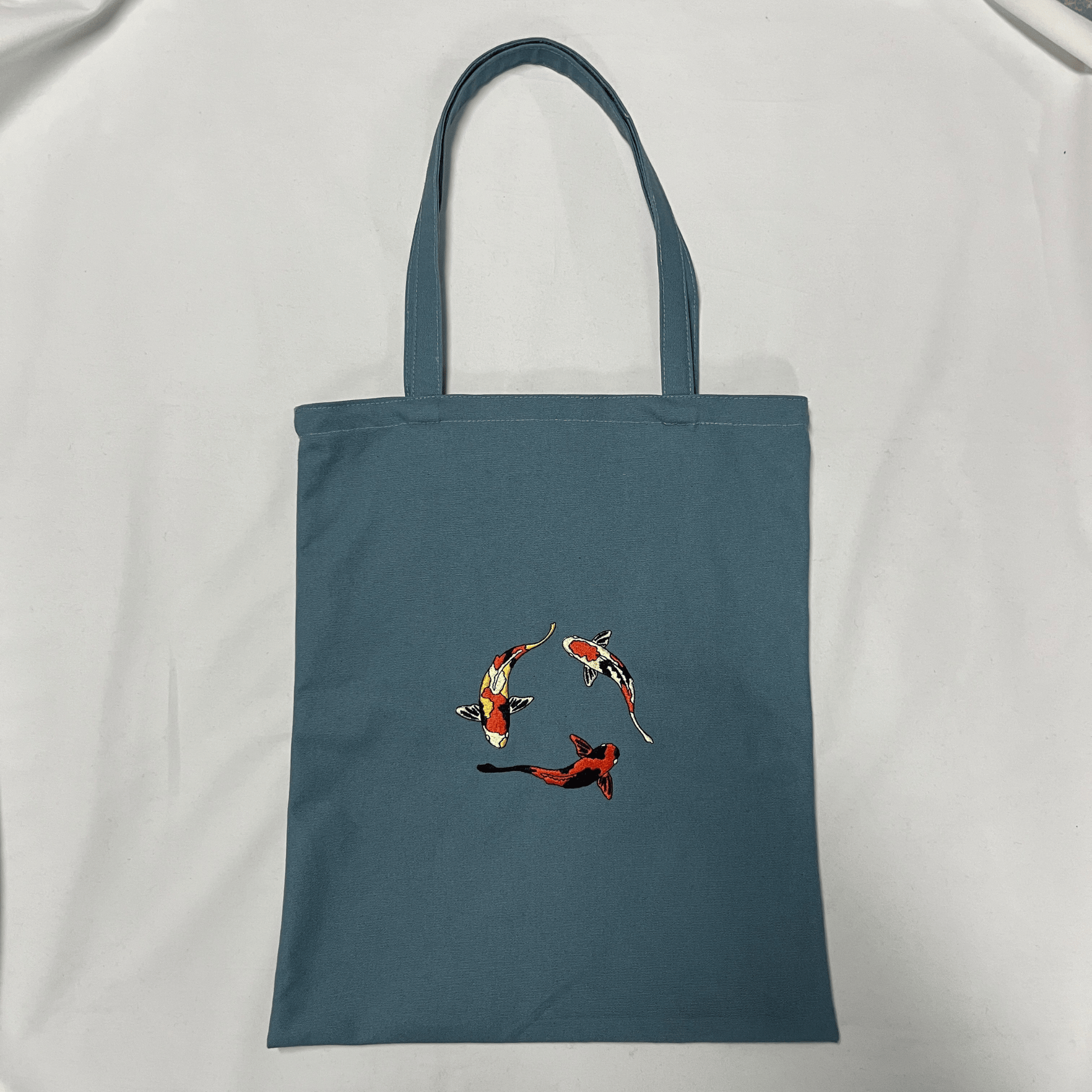Blue tote bag with fish design on a white background