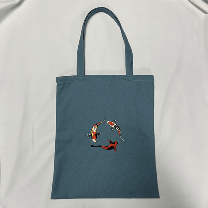 Blue tote bag with fish design on a white background