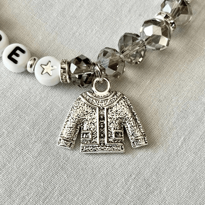 Bracelet with silver cardigan charm and beads on a light gray background