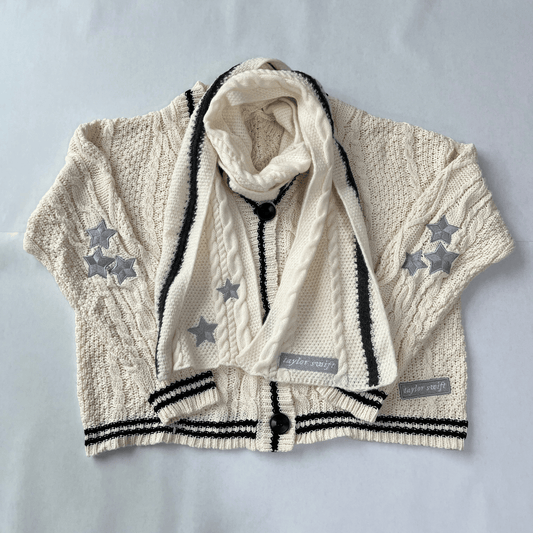 Children's cream cardigan with star patterns and a matching scarf on a light gray background