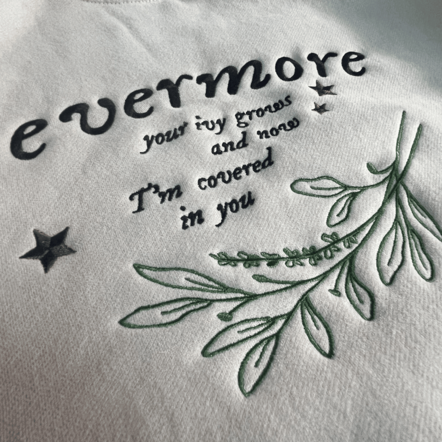 Embroidered text and leaves on a white fabric background