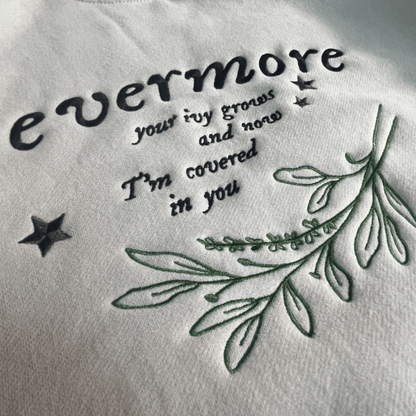 Embroidered text and leaves on a white fabric background