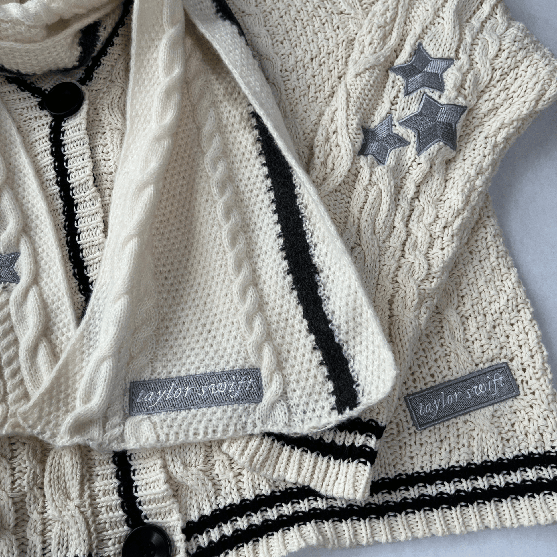 Knitted sweater with star patterns and 'Taylor Swift' labels on a light background