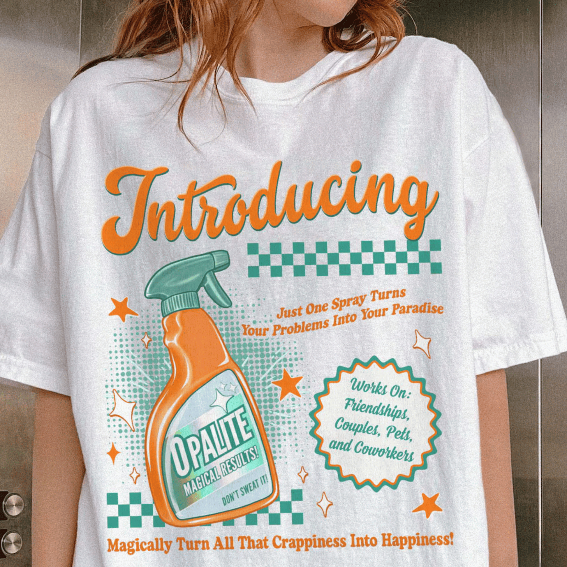 White t-shirt with a colorful graphic and text, featuring a spray bottle design.