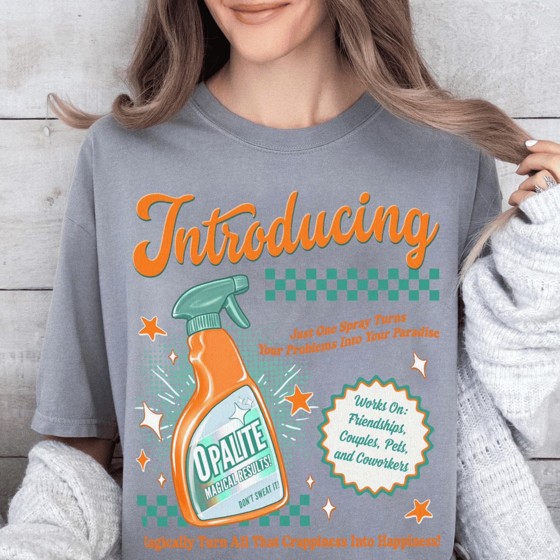 Person wearing a t-shirt with a graphic design of a bottle labeled 'Opalite' and text.