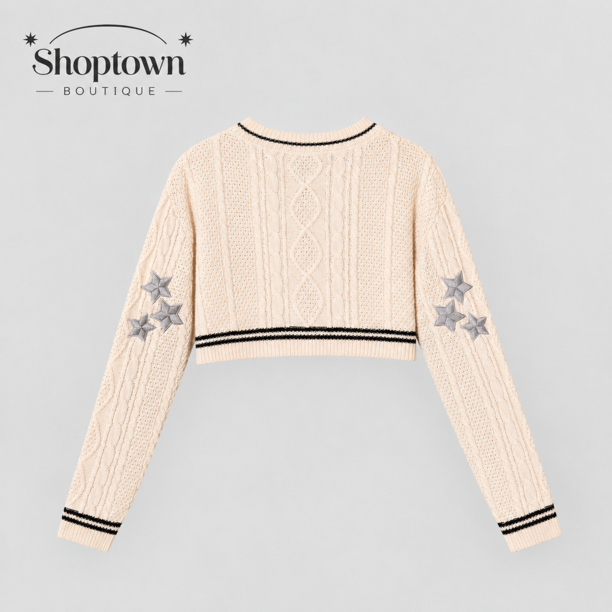 A cream-colored folklore knit cropped sweater with black striped trim and gray embroidered stars on the sleeves, shown from the back on a light gray background with the Shoptown Boutique logo in the top left corner.