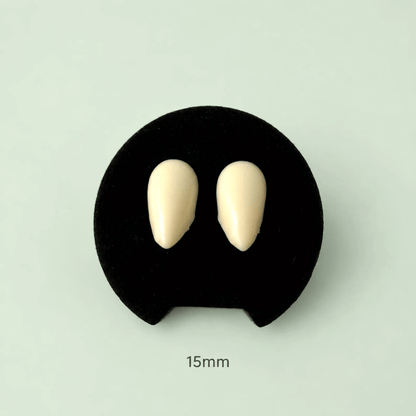 Two small oval cream-colored dental impression material pieces displayed on a black circular stand against a pale mint background, with '15mm' text below.