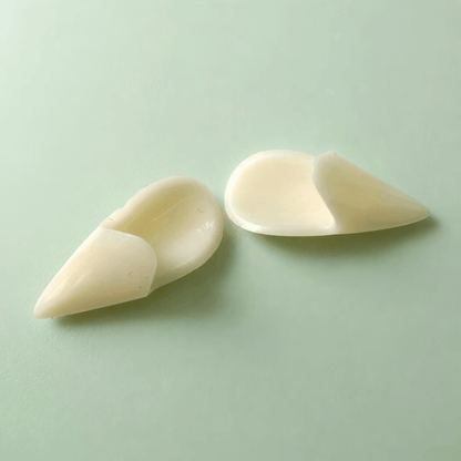 Two off-white silicone or rubber finger tips, likely for massage, therapy, or beauty purposes, displayed on a light mint green background.