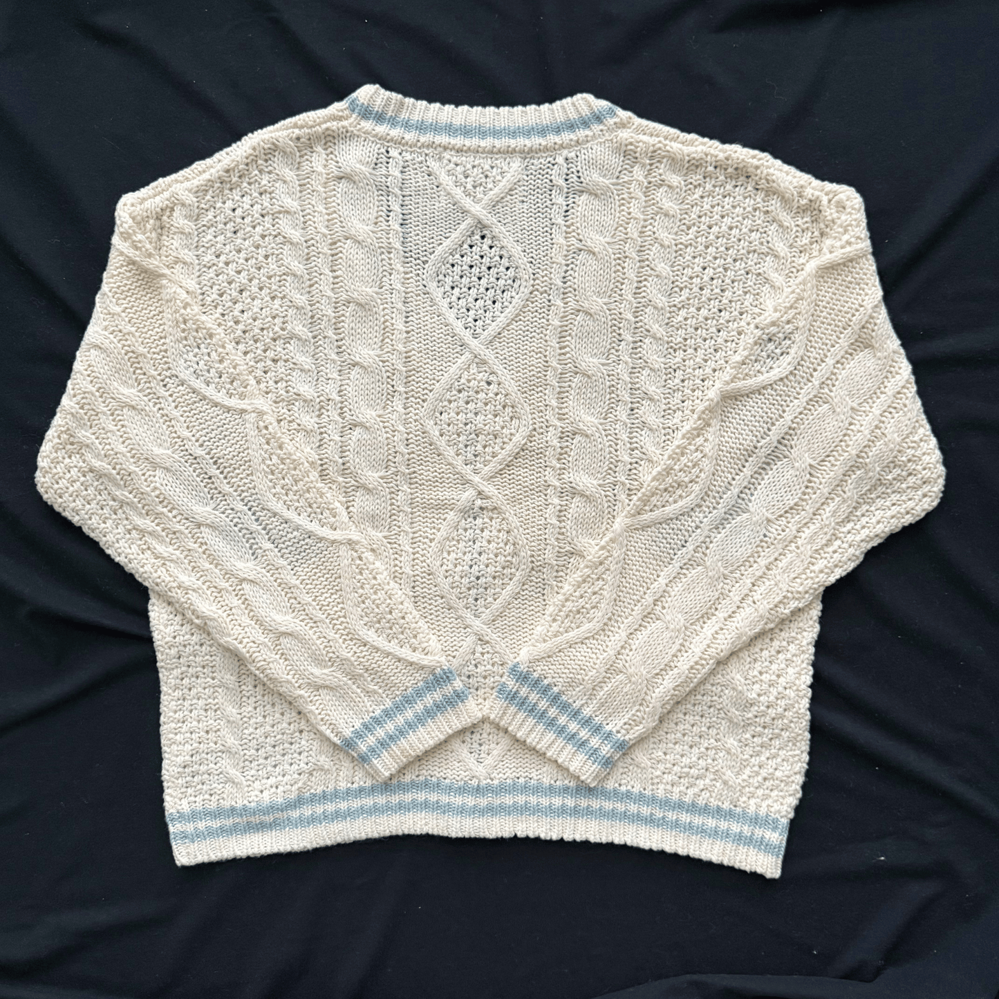 Knitted sweater with cable pattern on a dark background