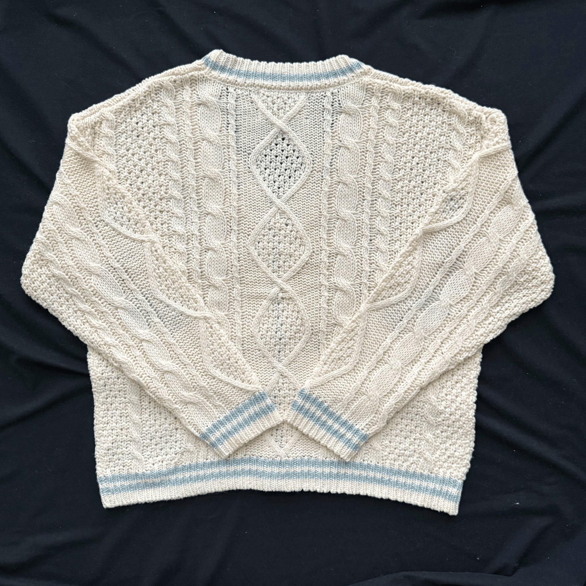 Knitted sweater with cable pattern on a dark background