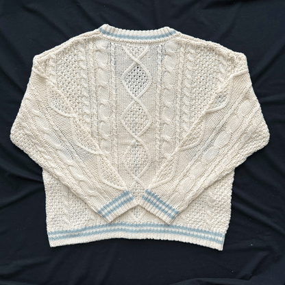 Knitted sweater with cable pattern on a dark background