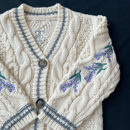 Knitted cardigan with embroidered lavender flowers on a dark background