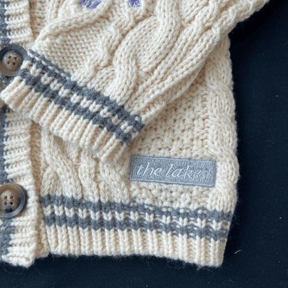 Close-up of a knitted cardigan with a brand label on a dark background