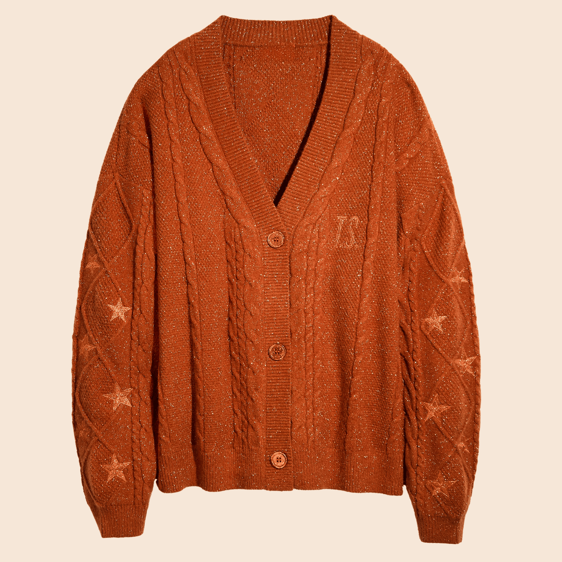Showgirl Orange knit cardigan with star patterns on a beige background