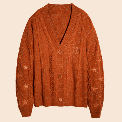 Showgirl Orange knit cardigan with star patterns on a beige background