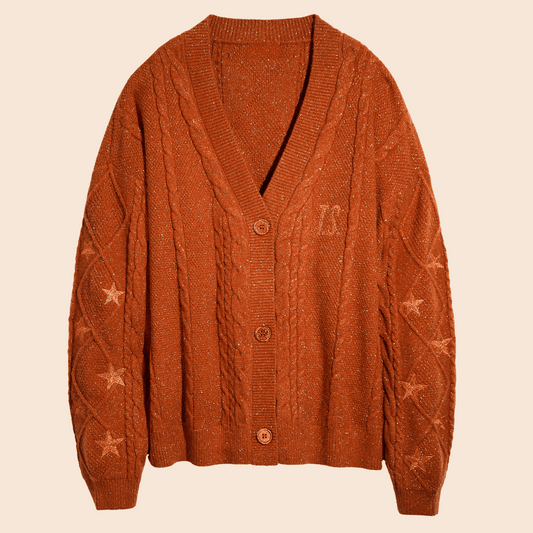 Showgirl Orange knit cardigan with star patterns on a beige background