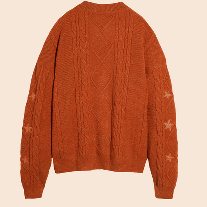 Brown cable knit sweater on a beige background