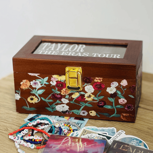 Taylor Swift Wooden Storage Box with floral embroidery and 'Taylor The Eras Tour' text, surrounded by memorabilia on a wooden surface  - Shoptown Boutique